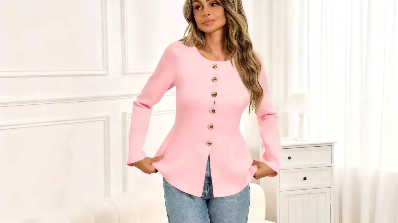A woman wearing a Cicybell Women’s Pink Button-Up Cardigan Sweater leans against a wall indoors.