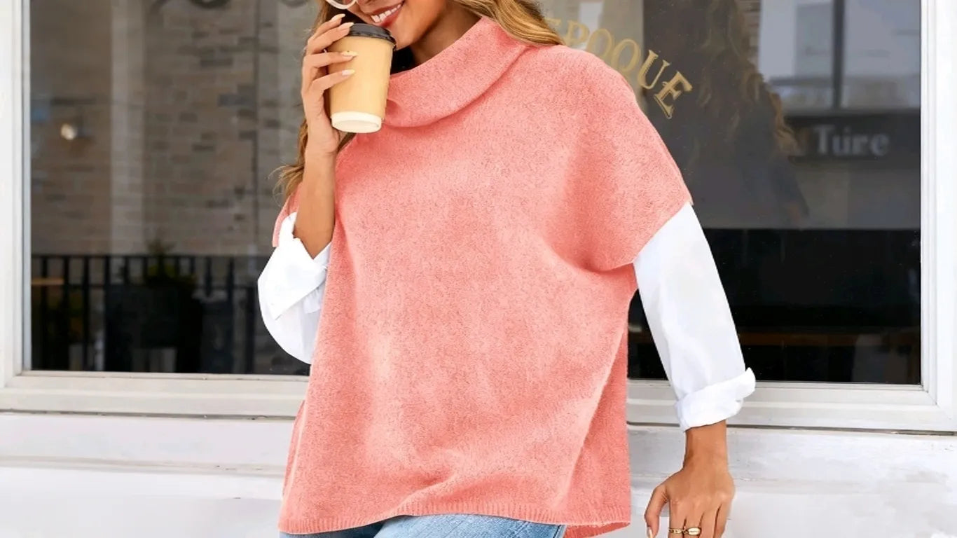 A woman wearing the Cicy Bell Women’s Pink Oversized Turtleneck Poncho Sweater enjoys coffee by the roadside.