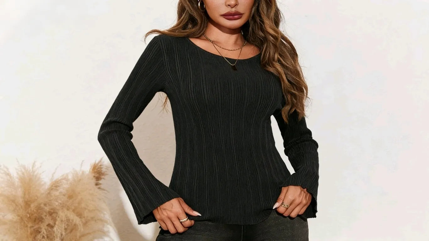 A woman is taking photos while wearing a black tight-fitting sweater.