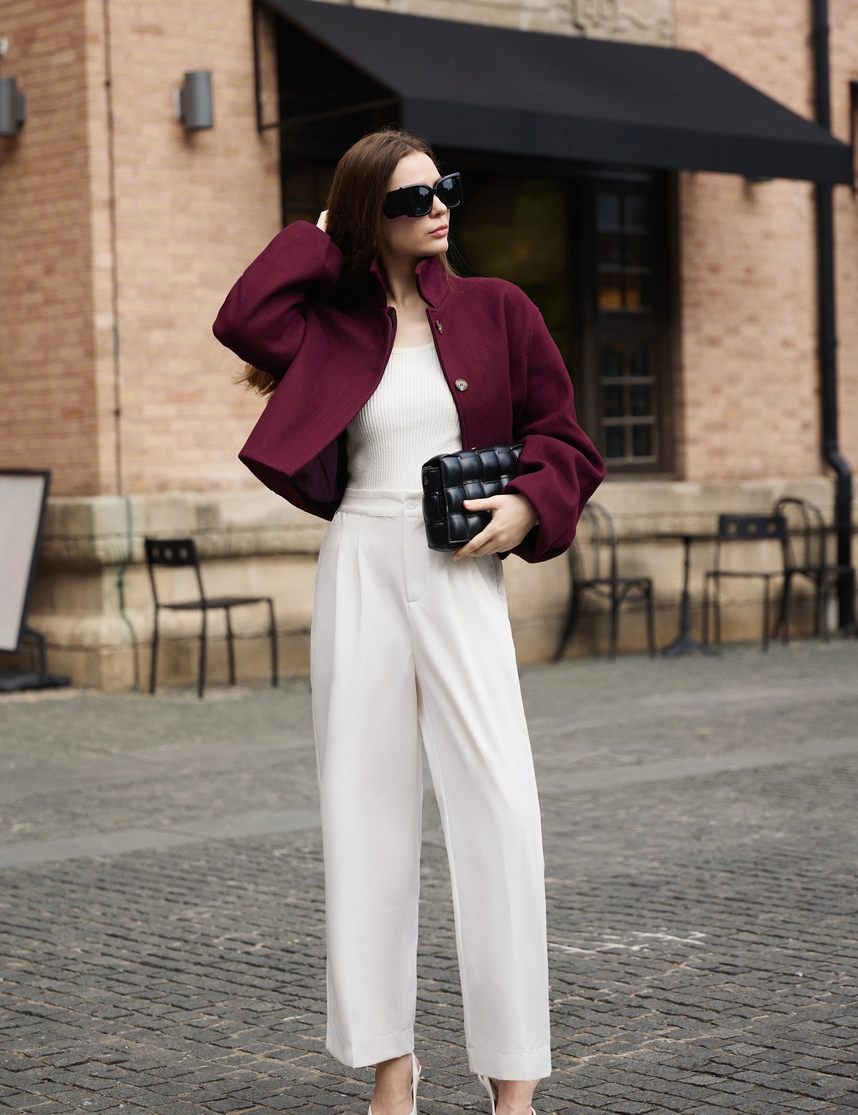 Professional woman wearing a smart casual outfit with a Cicy Bell burgundy cropped pea coat and white high-waisted wide-leg trousers
