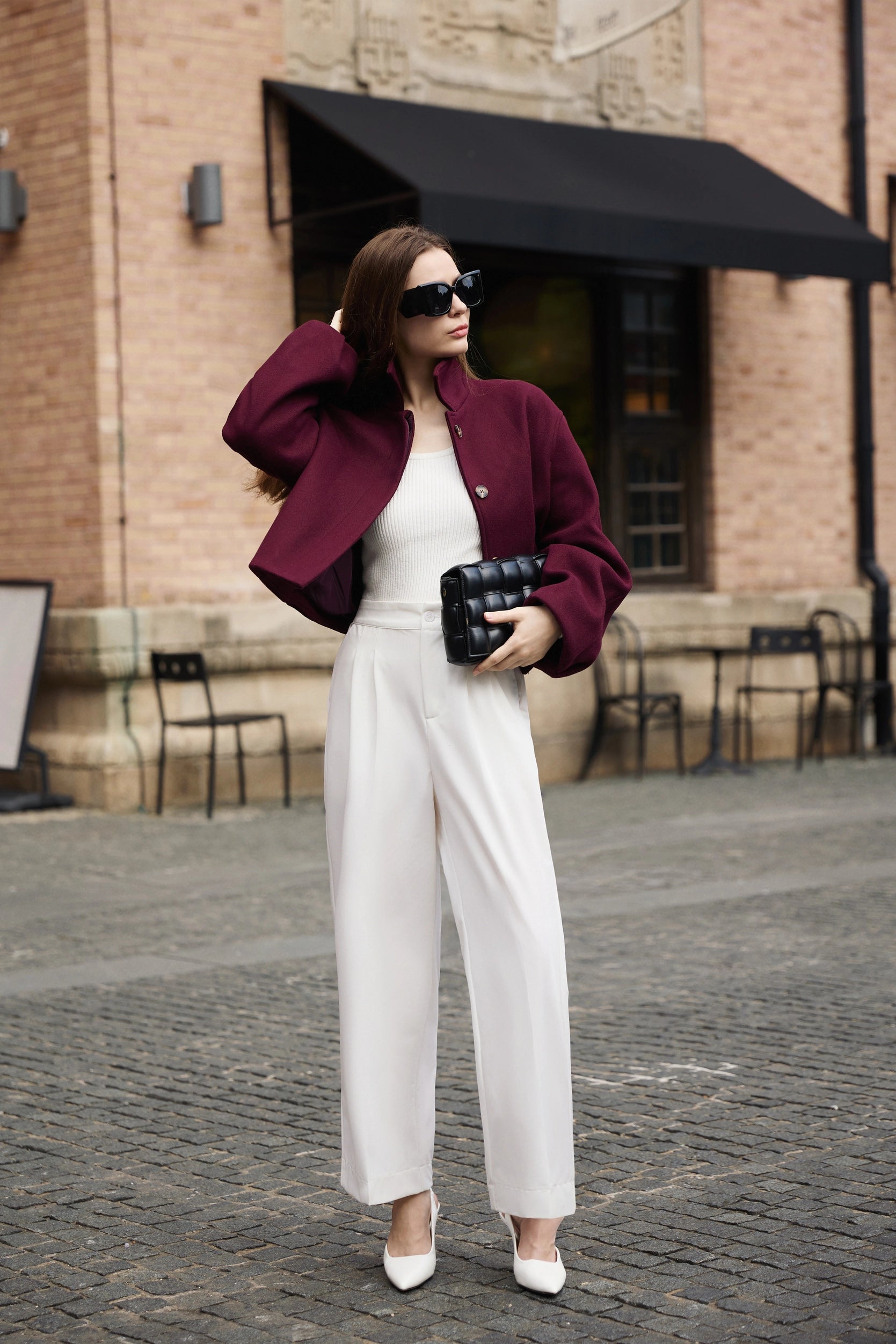 Professional woman wearing a smart casual outfit with a Cicy Bell burgundy cropped pea coat and white high-waisted wide-leg trousers