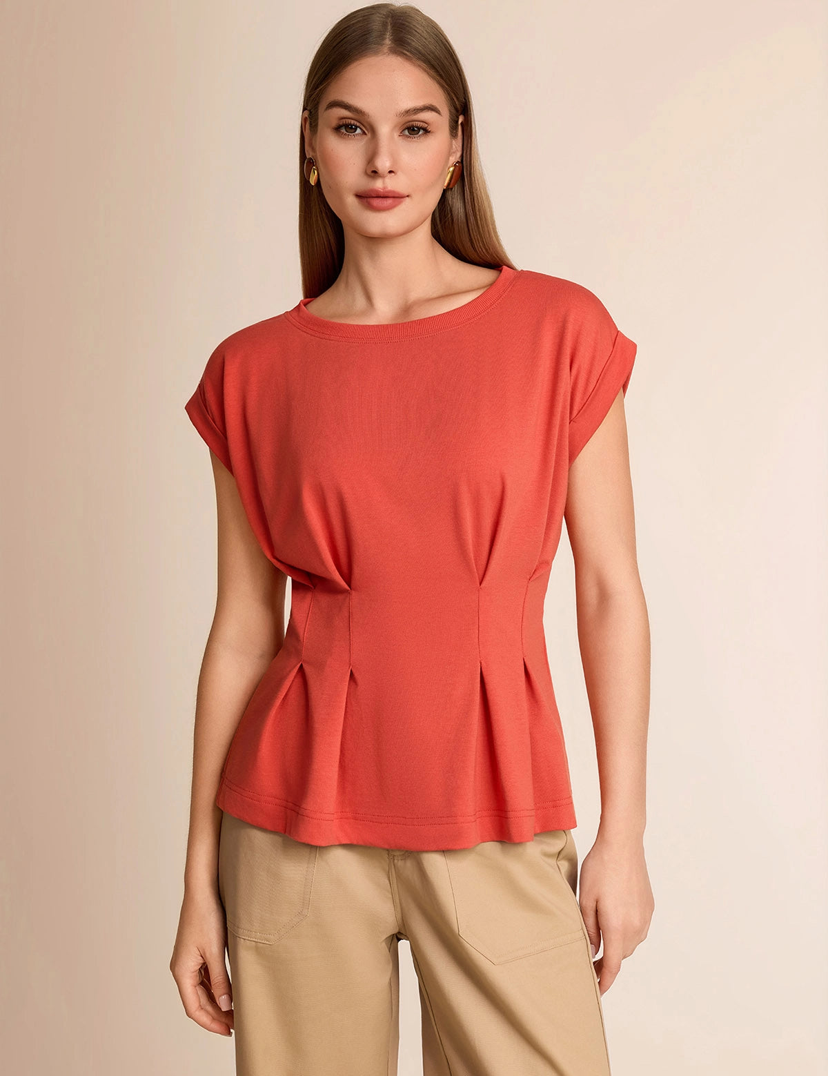 Professional woman wearing a smart casual brick red cap sleeve top with a flattering pleated peplum waist