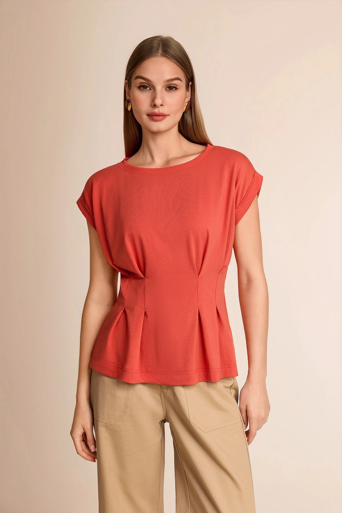 Professional woman wearing a smart casual brick red cap sleeve top with a flattering pleated peplum waist