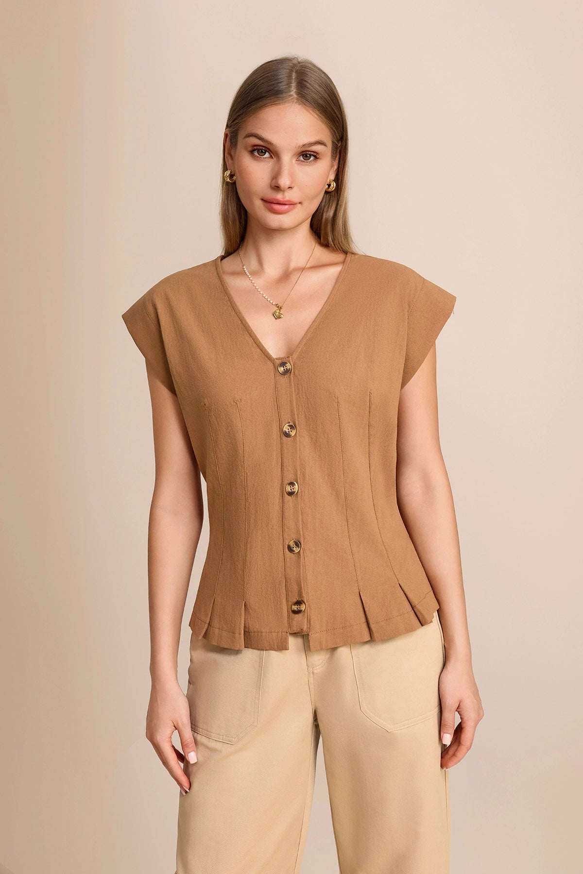 Professional woman wearing a dark khaki 100% cotton V-neck vest with cap sleeves