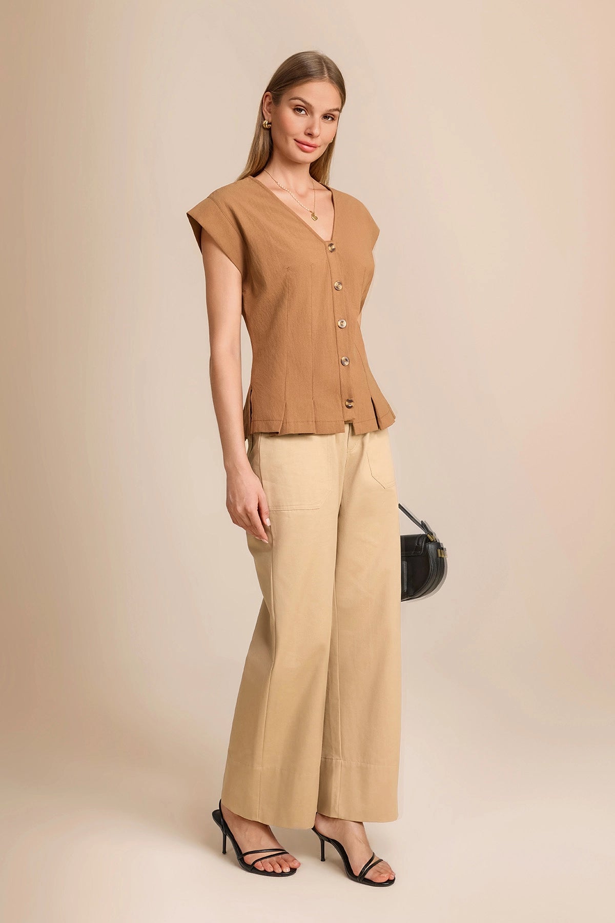 Monochromatic summer 2026 outfit featuring a dark khaki cinched waist vest paired with beige wide-leg trousers