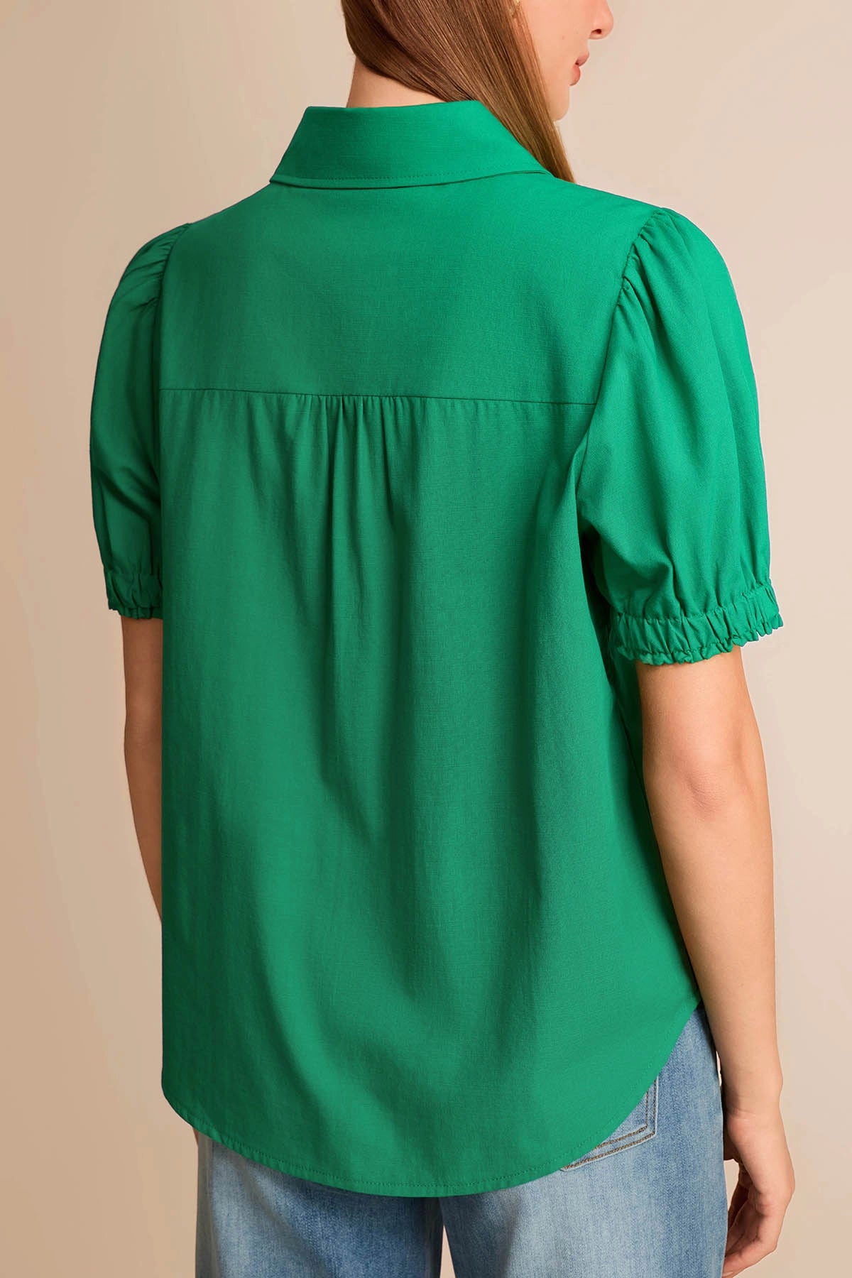 Back view of a flowy green cotton viscose blend blouse with short puff sleeves