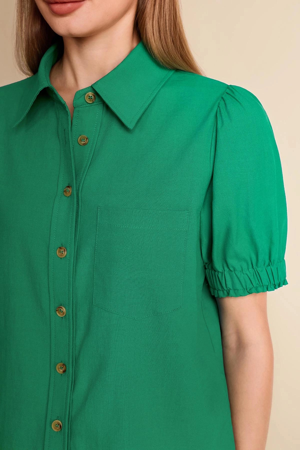 Close-up of elegant ruffle accents on the elasticized puff sleeve of a women's green work shirt