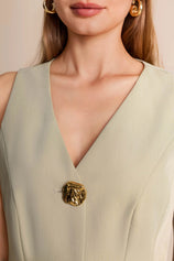 Close-up of vintage gold button details on a tailored olive green V-neck sleeveless blazer vest