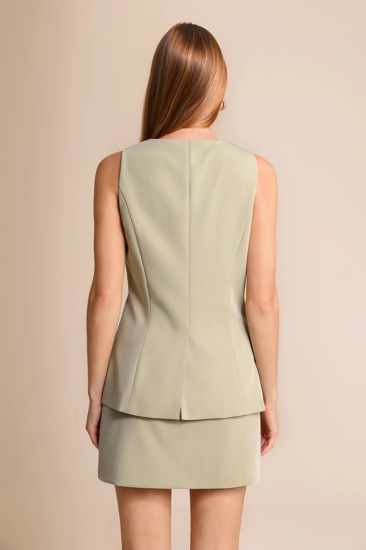 Summer suiting trend featuring an olive green tailored vest with split hem and matching skirt