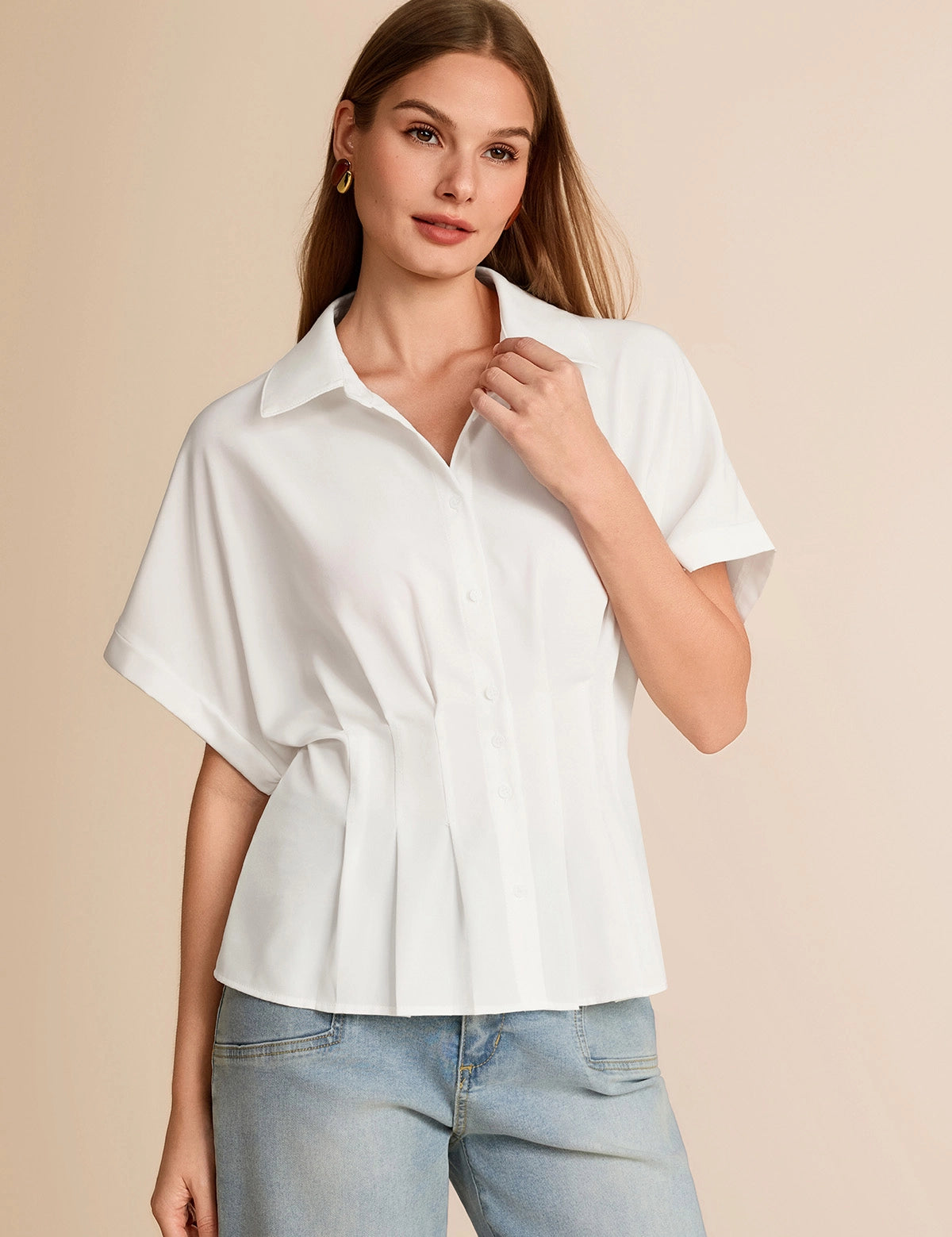 Professional woman wearing a white short-sleeve peplum top with elegant pleating and a fitted waist