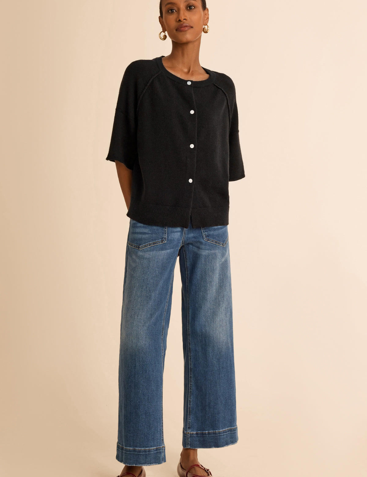 Cicy Bell Women's Button-Down Cardigan featuring trendy half sleeves and chic exposed seam detailing. This lightweight cropped knit sweater offers a relaxed drop shoulder silhouette and a ribbed crew neck for a cozy yet polished spring layer.