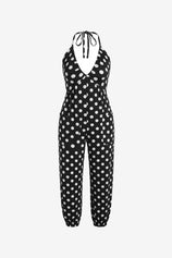 A bold and vibrant Cicy Bell halter neck jumpsuit in a breezy, lightweight fabric. Highlights the flattering plunging V-neckline and relaxed jogger silhouette, designed as a "one-and-done" vacation essential for beachside brunches or sunset parties.