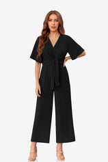CicyBell Women's Black Wide-Leg Romper featuring an elegant tie-knot front and flowy flutter sleeves. This chiffon-feel one-piece outfit offers a flattering V-neckline and elastic waist, perfect for beach weddings or office wear.