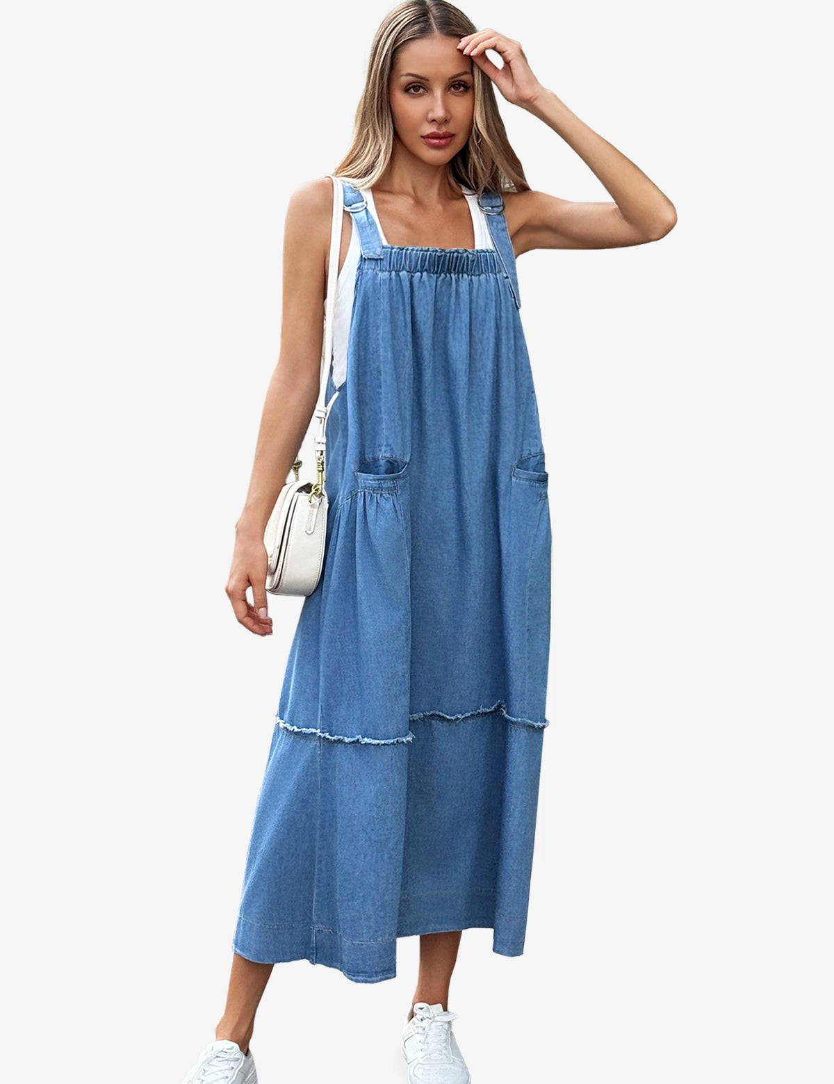 A modern boho-chic Cicy Bell denim maxi dress with a multi-tiered silhouette and shabby-chic fringe accents. Highlights the adjustable metal buckles and oversized aesthetic, perfect for layering over tees or sweaters for farmers' market runs or casual coffee dates.