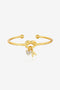 Cicy Bell Women's 18k Gold Plated Initial Bangle featuring a symbolic love knot design and a sparkling CZ heart charm. This personalized open-cuff bracelet offers an adjustable $60\text{mm}$ fit for bridesmaids or best friends.