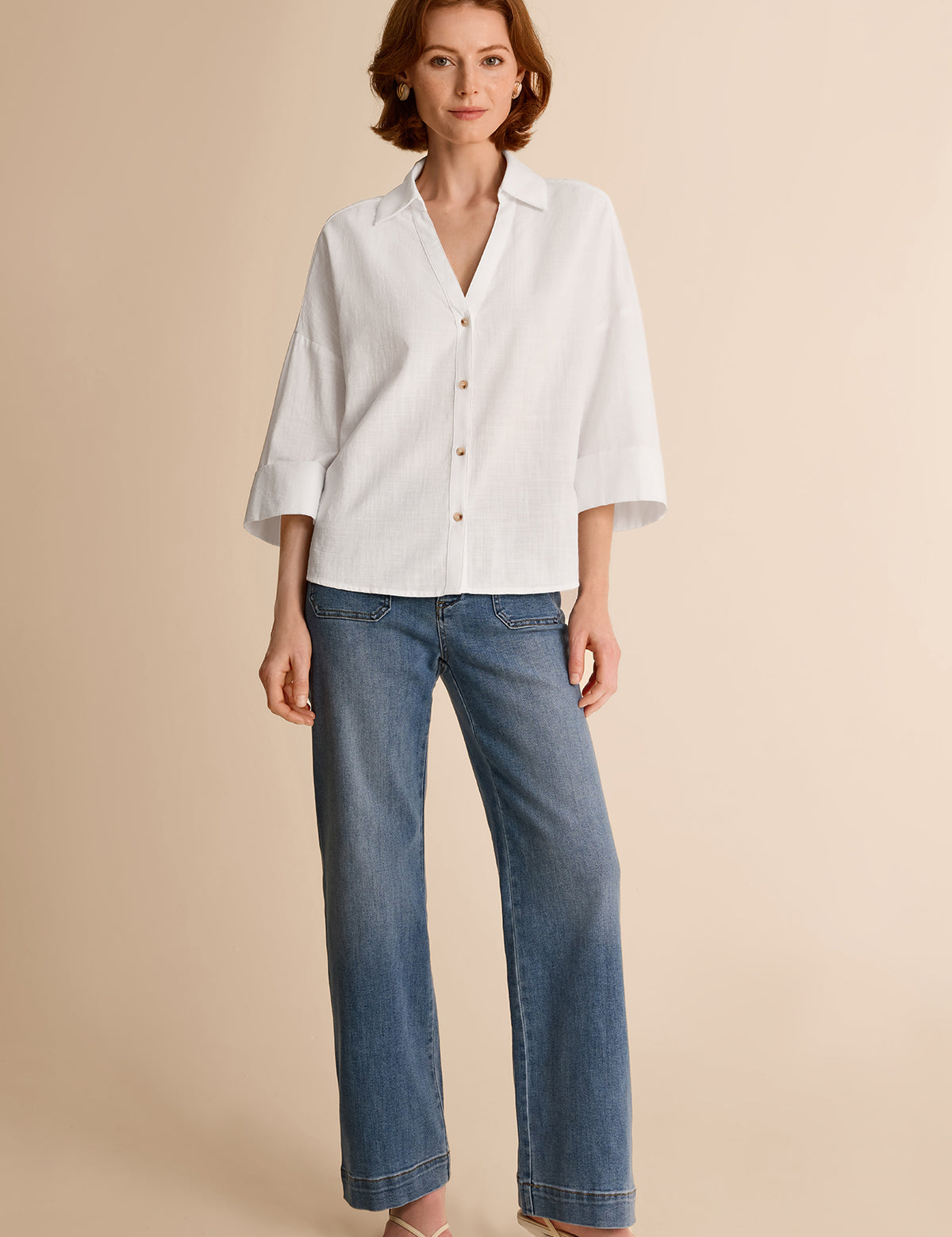 Summer office outfit idea featuring an oversized white cotton blend blouse tucked into straight-leg blue jeans