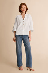 Summer office outfit idea featuring an oversized white cotton blend blouse tucked into straight-leg blue jeans