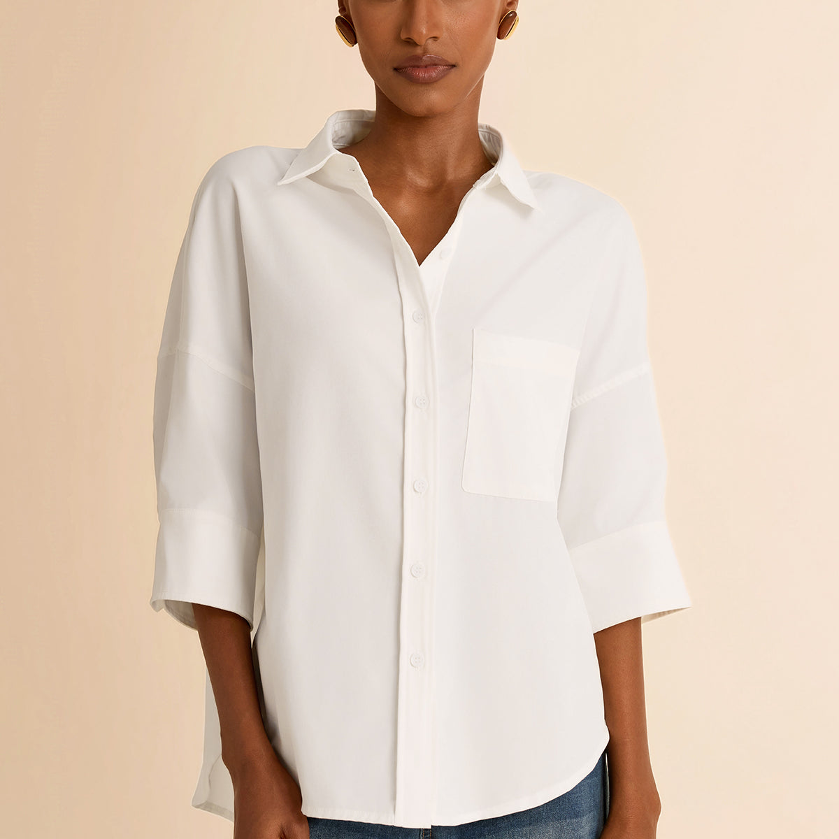 Modern professional woman wearing a crisp white oversized button-down shirt with a chest pocket